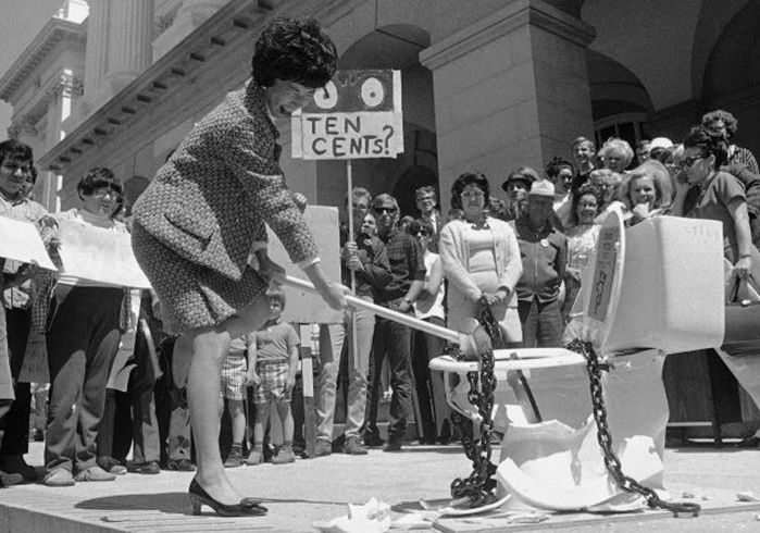 March Fong Eu smashes a toilet in front of California state capitol building with crowd watching.