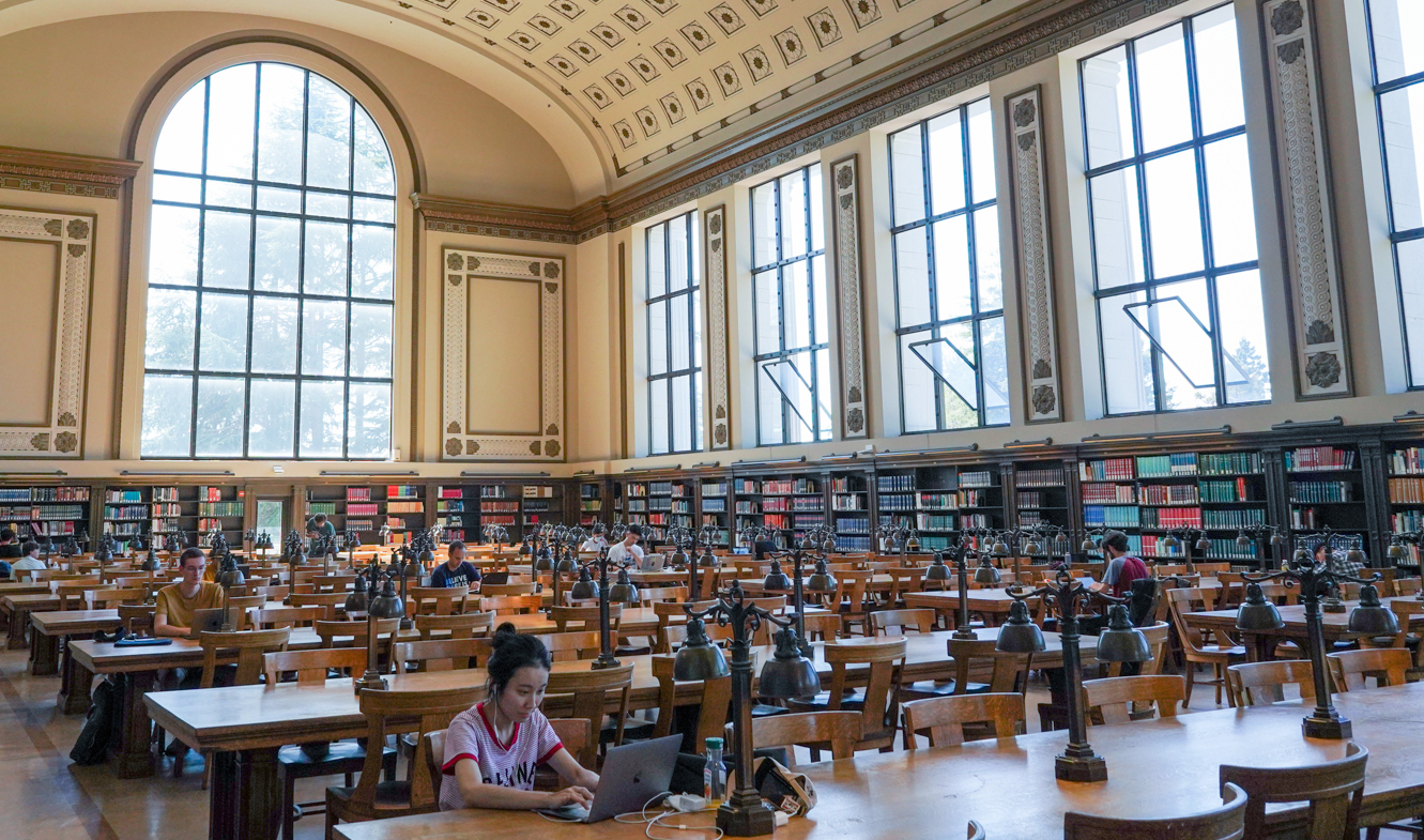 people work on laptops in the sunny north reading room