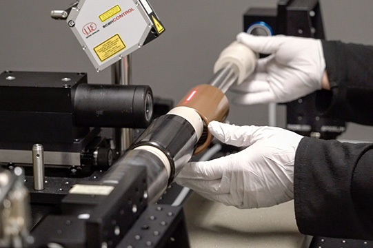 Hands putting cylinders on scanner