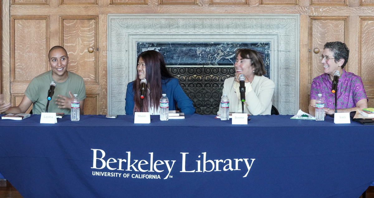 Speakers sit at a table in Morrison Library