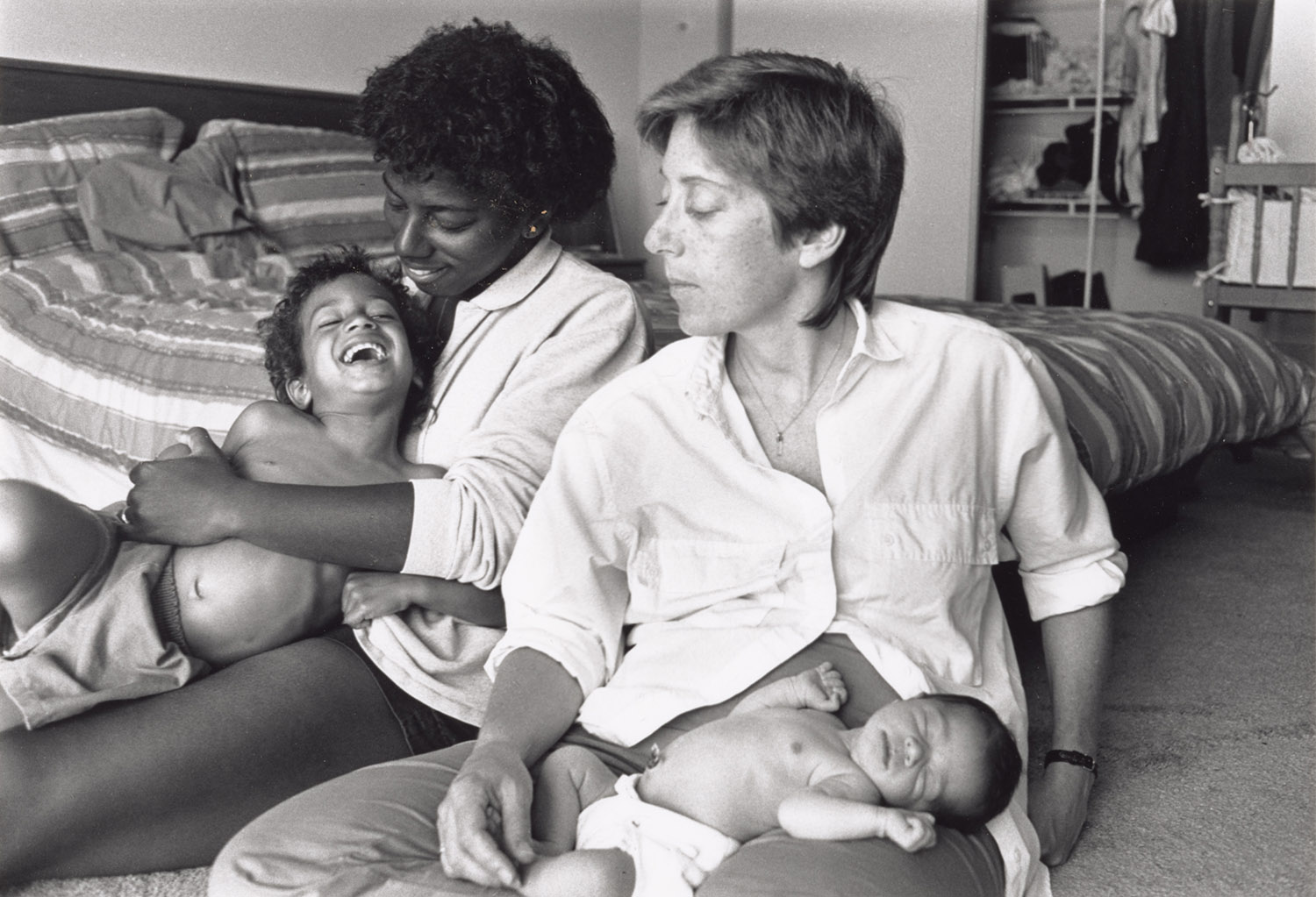 Two mothers with kids sitting on floor